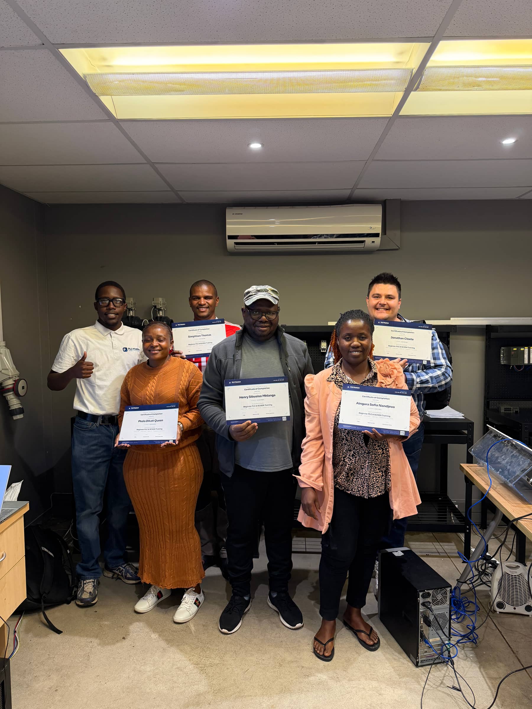 PLC Masters graduates holding their certificates